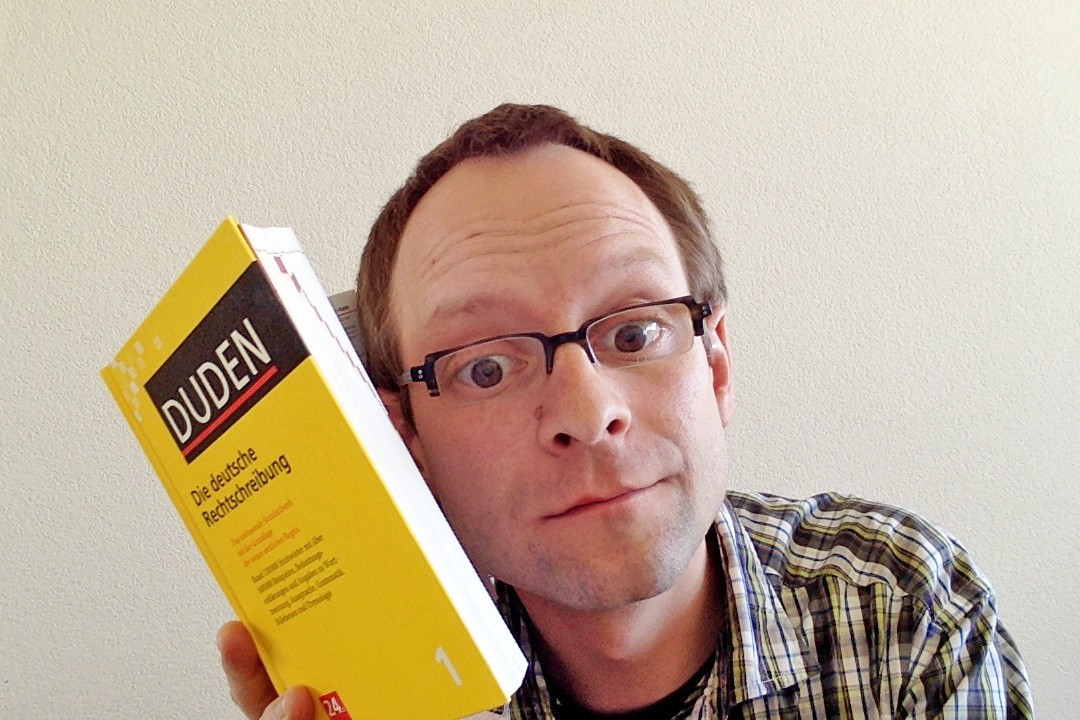 Bild: Mann lauscht am Duden